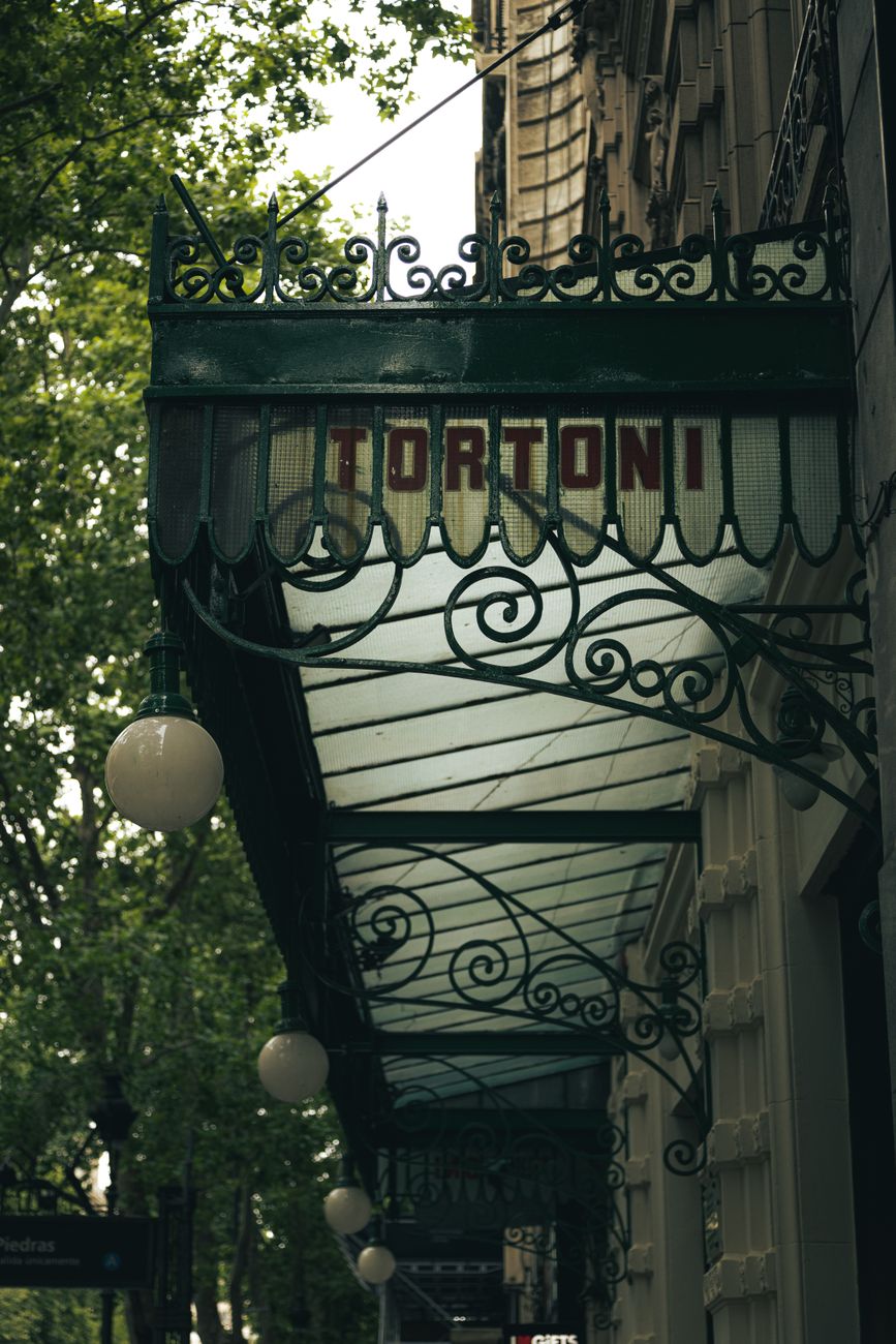 Calle empedrada con cafés de Buenos Aires y arquitectura europea